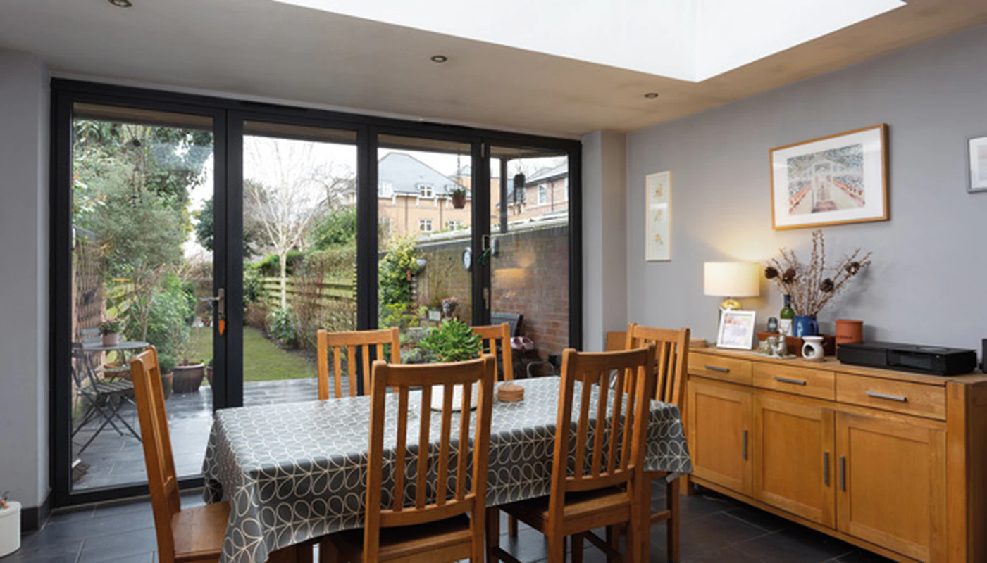 Dining space with full-height glazed doors overlooking garden in listed shop conversion, York