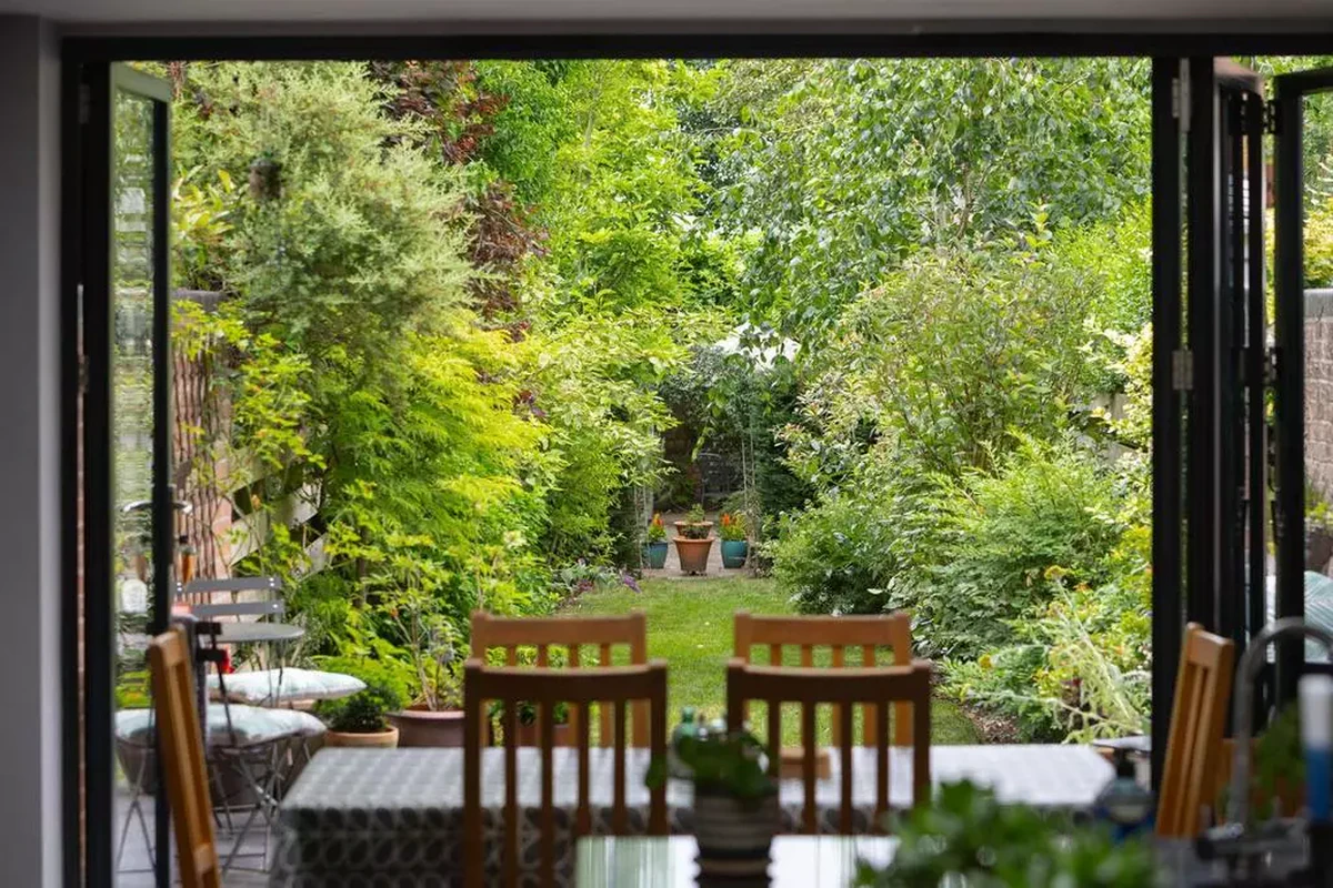 View through open bifold doors to long garden from rear extension, listed home York