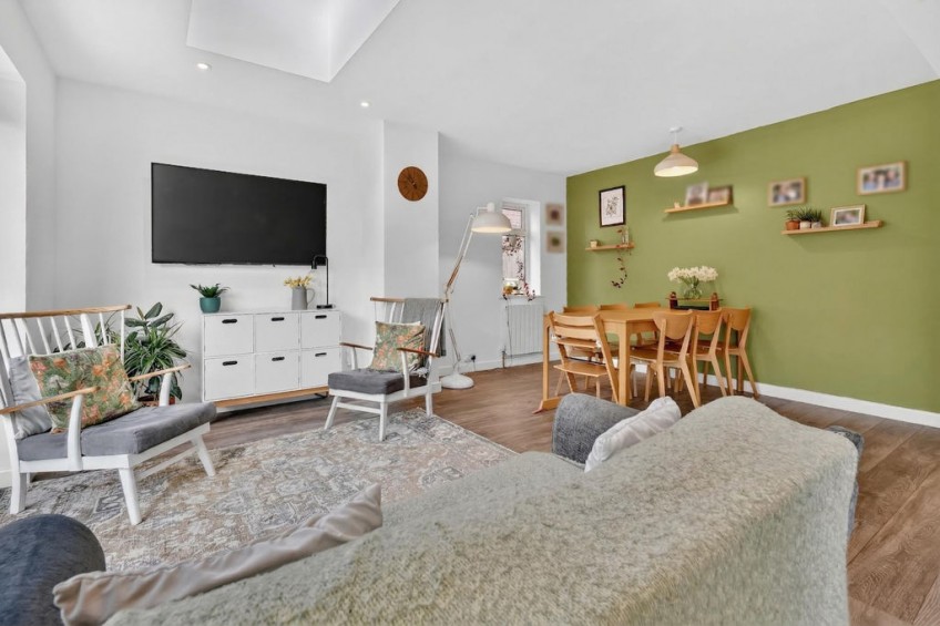 Bright family living and dining space with large sliding doors out to the garden and overhead skylights, highlighting the 50 square metre uplift from the two storey front and rear extension.
