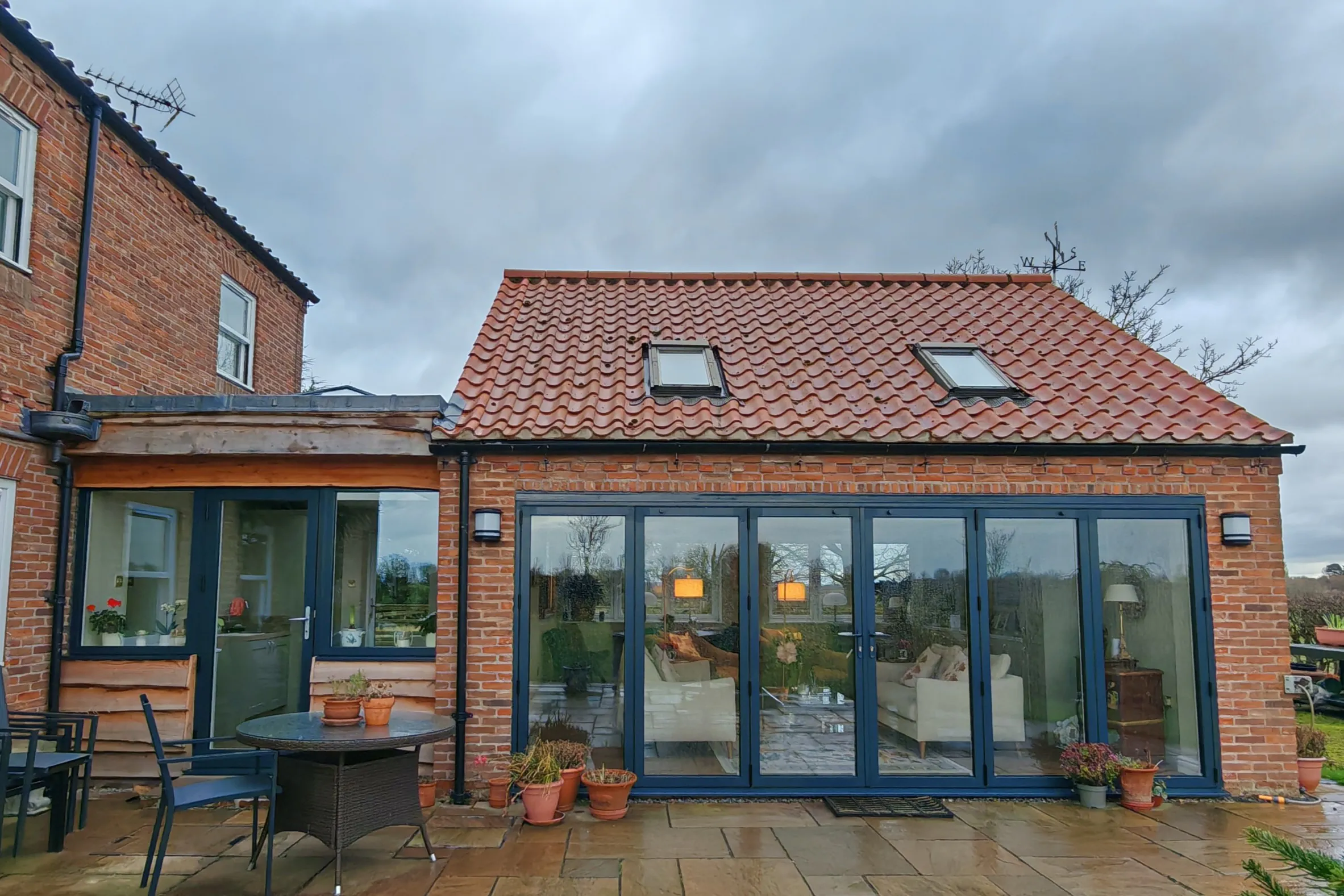 Exterior of converted garage and link to provide habitable space with garden views through wide bifold doors, in Nether Poppleton, York, North Yorkshire