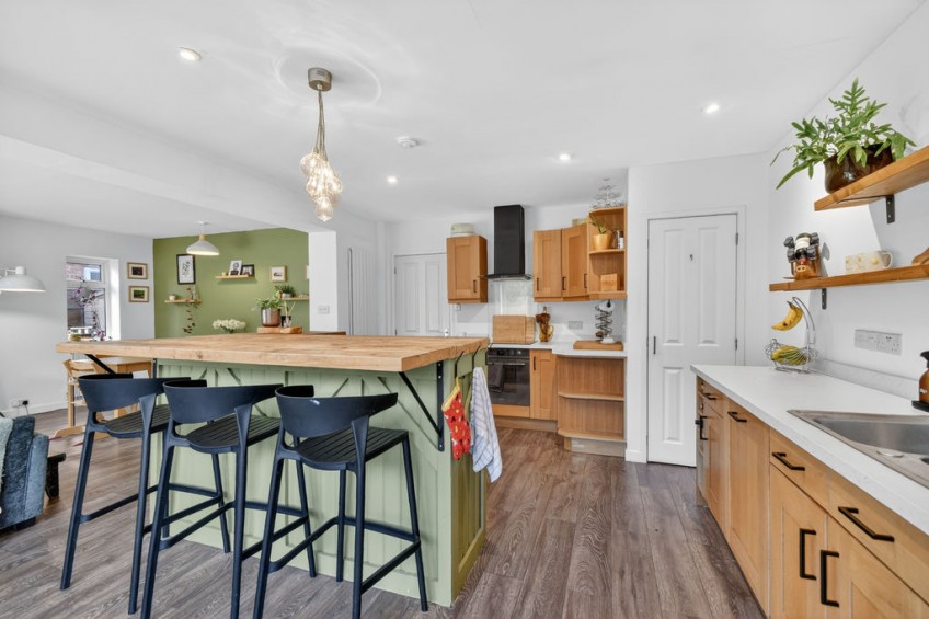 Newly fitted wooden kitchen with a green breakfast bar island, created as part of the spacious open-plan layout in a two storey front and rear extension project in York.
