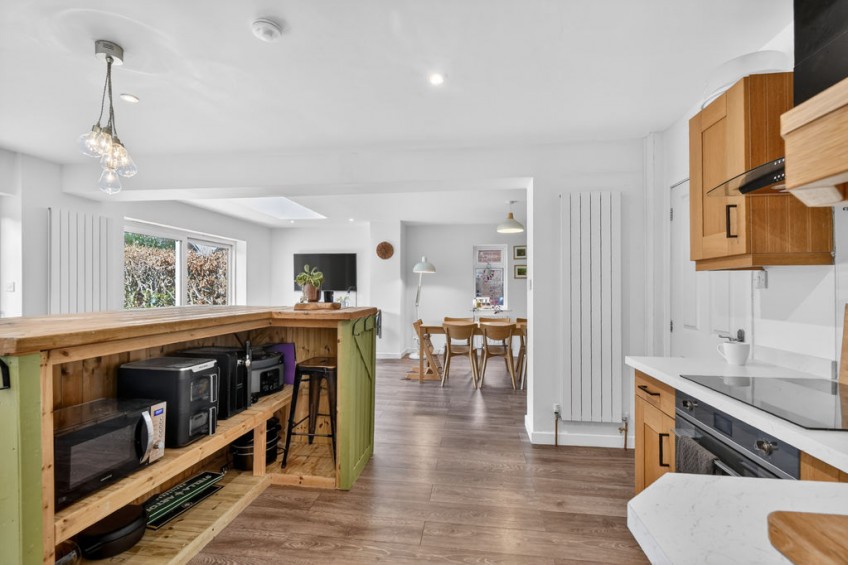 Newly fitted wooden kitchen with a green breakfast bar island, created as part of the spacious open-plan layout in a two storey front and rear extension project in York.