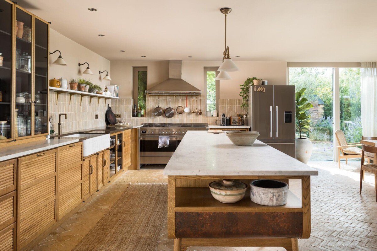 Bespoke timber kitchen with marble island in period property extension, Nether Poppleton York, with herringbone brick floor and garden beyond