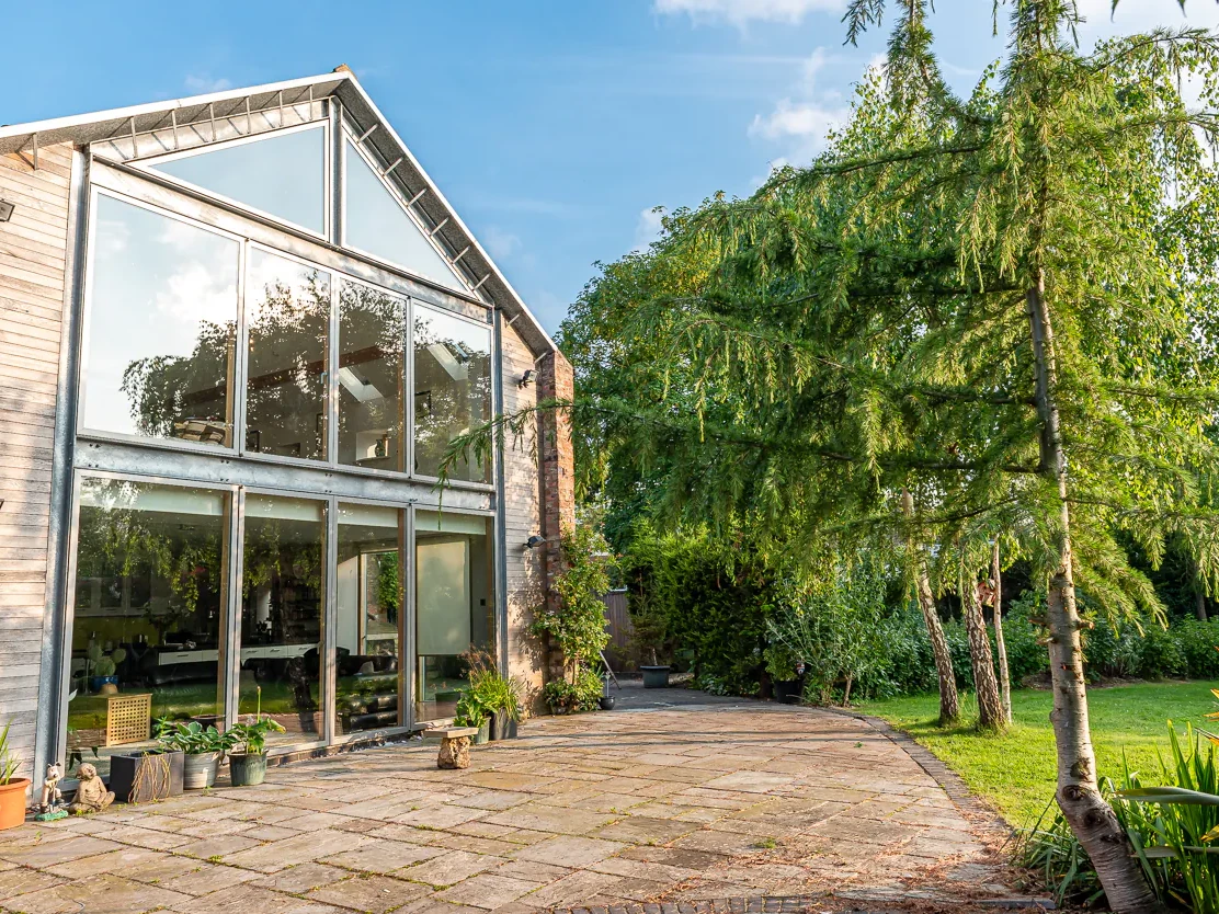 Cedar-clad double storey extension with full-height glazed gable and sliding doors, Nether Poppleton conservation area, York