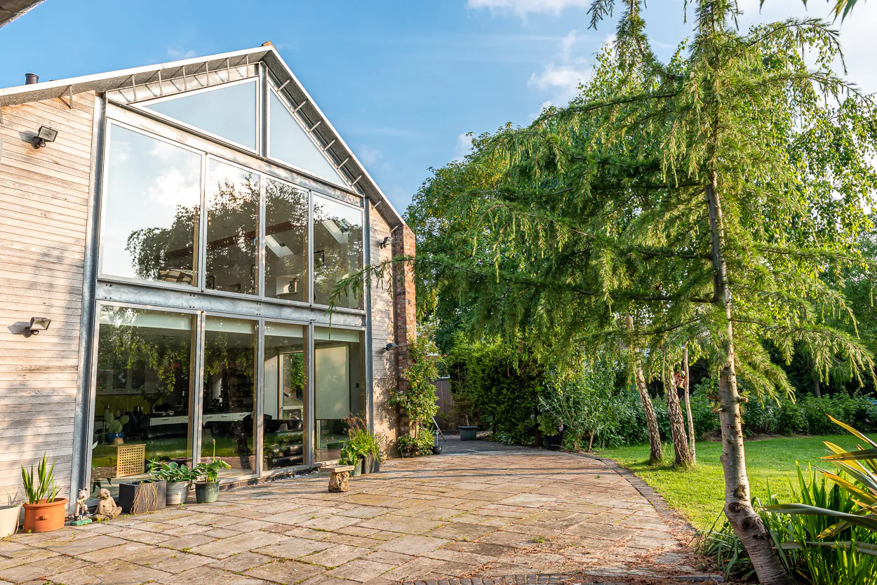 Cedar-clad double storey extension with full-height glazed gable and sliding doors, Nether Poppleton conservation area, York