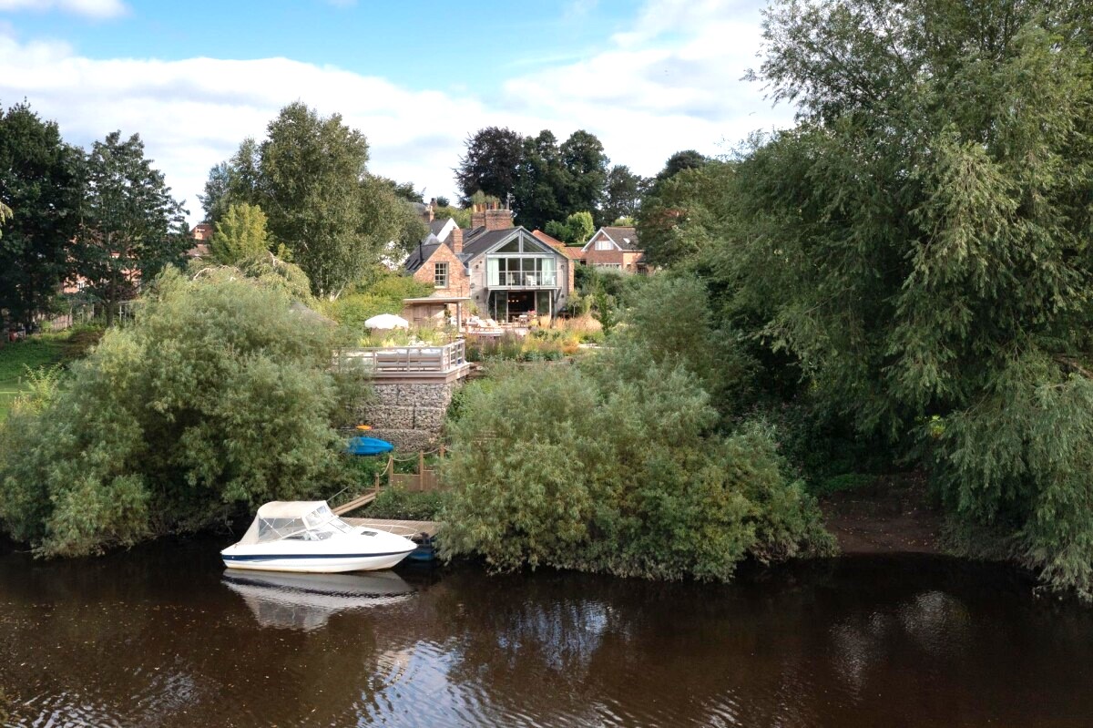 View from the River Ouse of double storey extension in Nether Poppleton conservation area York, with private mooring and riverside setting