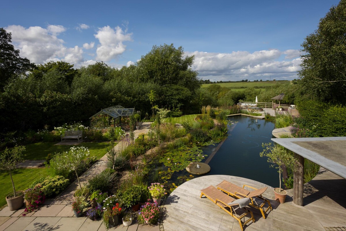 Landscaped riverside garden with natural swimming pool viewed from double storey extension balcony, Nether Poppleton York
