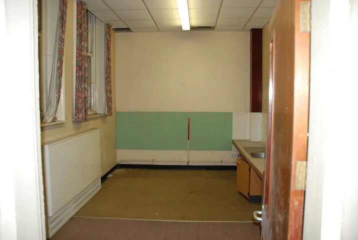 A stripped-out room inside the former Shipton Street School, featuring dated sinks and bare flooring prior to the sympathetic conversion of the listed building.