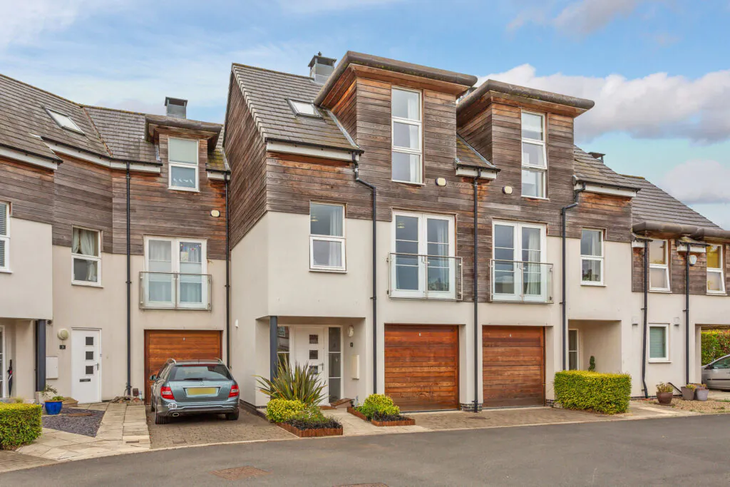 Contemporary extension listed building townhouses featuring dark grey upper cladding and red brick lower halves at the Bootham Green development.