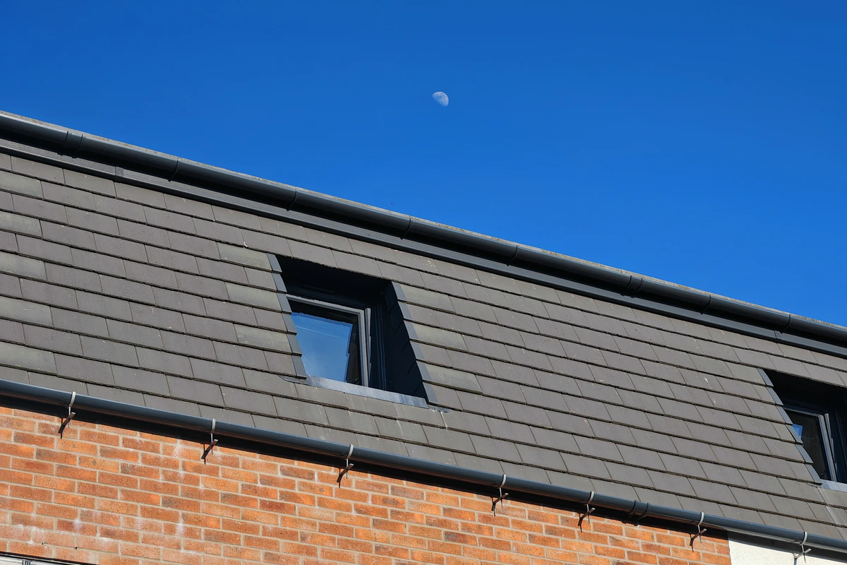 Close-up of the dark grey slate mansard roof with a square recessed dormer rooflight at Hawthorn Street Apartments, Layerthorpe York — architectural roof detailing on a 10-unit brownfield residential scheme by Fining Associates.