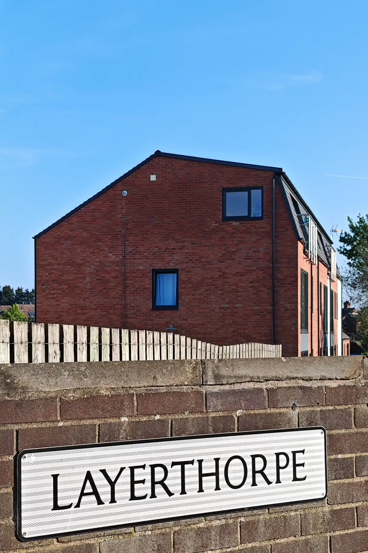Layerthorpe street sign with the completed Hawthorn Street residential apartment building rising behind, illustrating the scale and context of this brownfield urban infill development in York by Fining Associates.