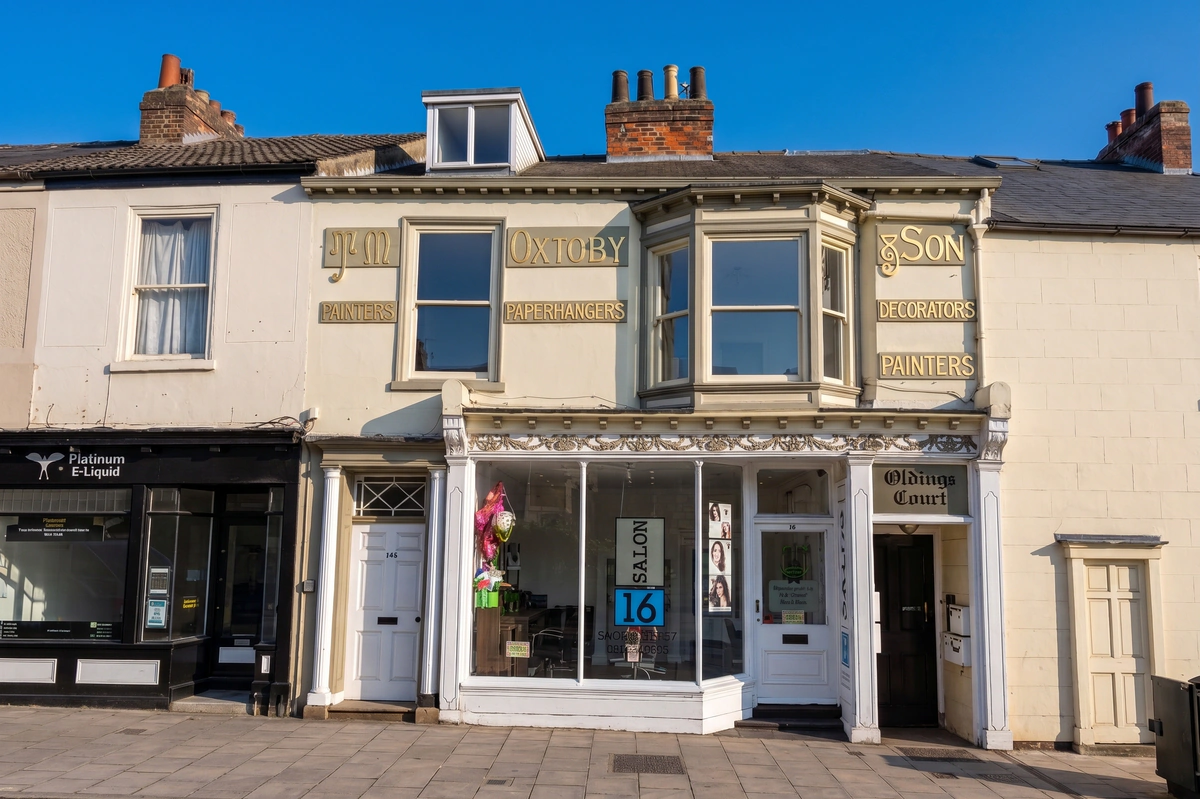Grade II listed Victorian shopfront with canted bay window and original painted fascia signage, Fishergate, York — heritage building conservation and listed building consent by a York conservation architect